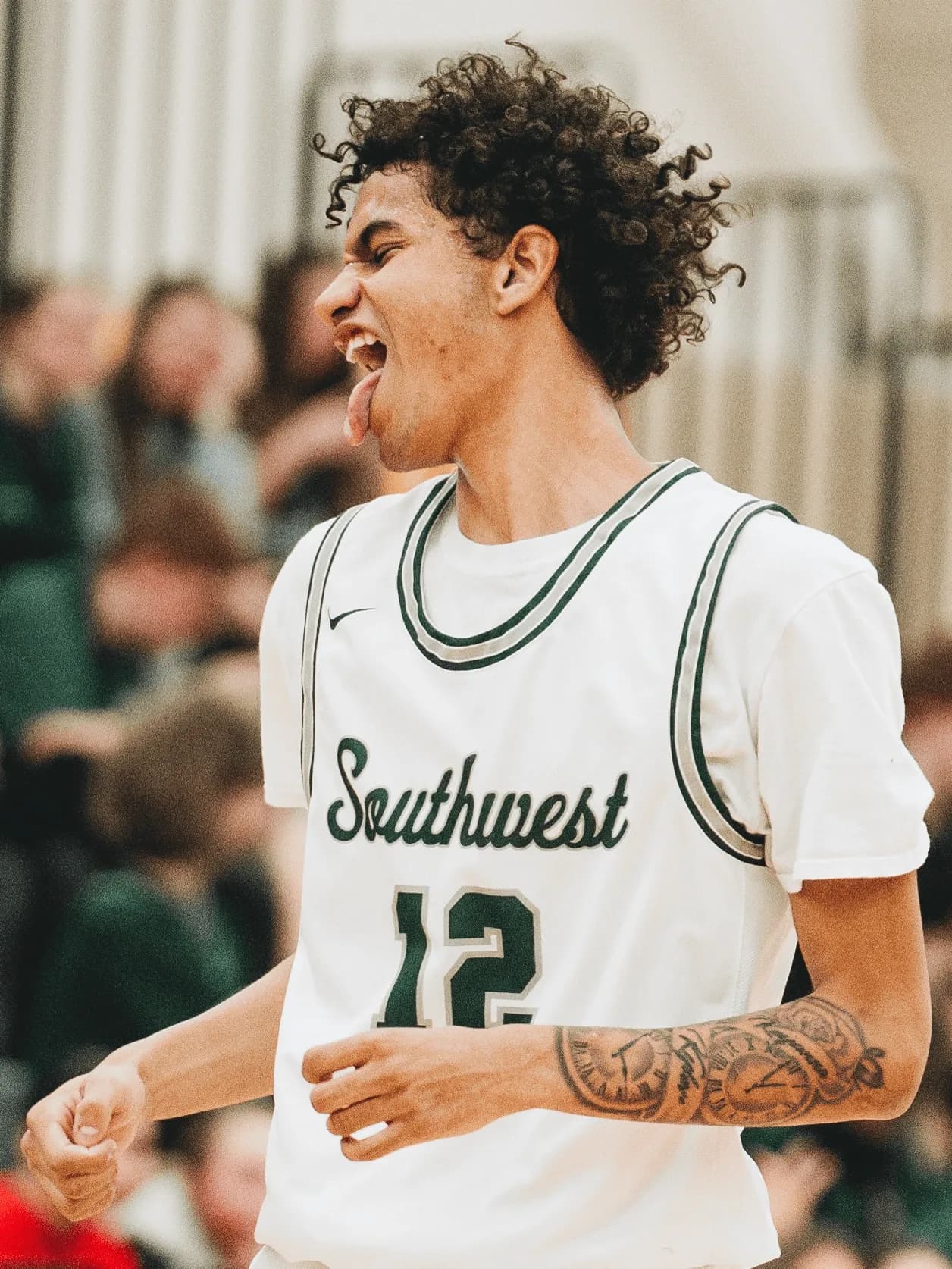A Lincoln Southwest Silver Hawks guard wearing No. 12 celebrates after hitting a three-point shot.