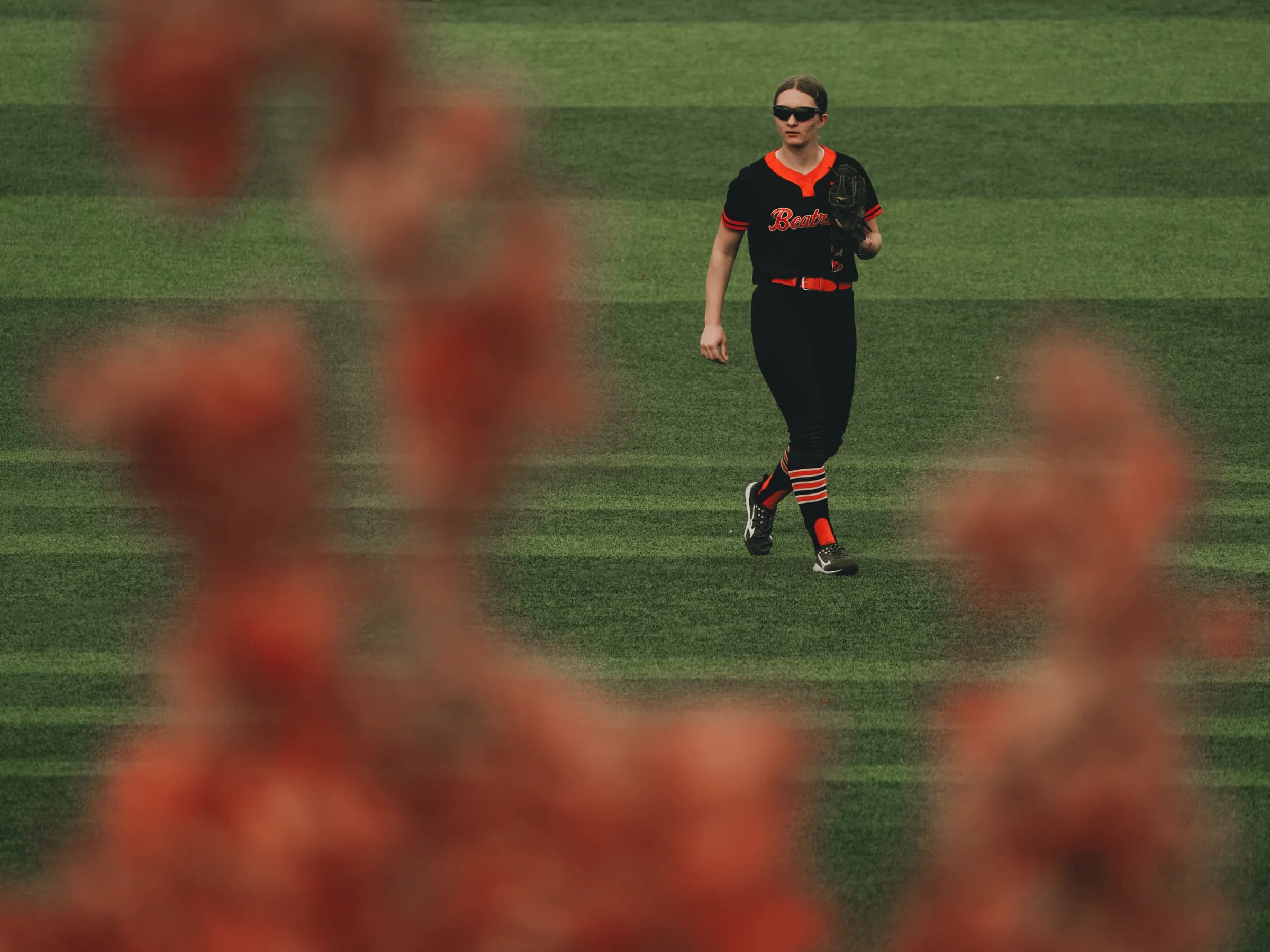 A Beatrice outfielder walks across the grass during the Class B state softball championship game
