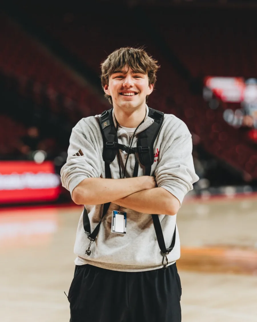 Eli Larson standing on a basketball court, arms crossed